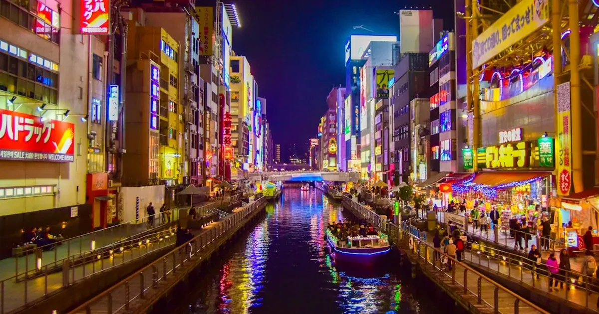 Dotonbori canal in Osaka at night with neon lights reflecting brilliantly on the water