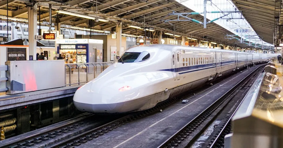 White Shinkansen bullet train at a Japan Rail station platform ready for departure