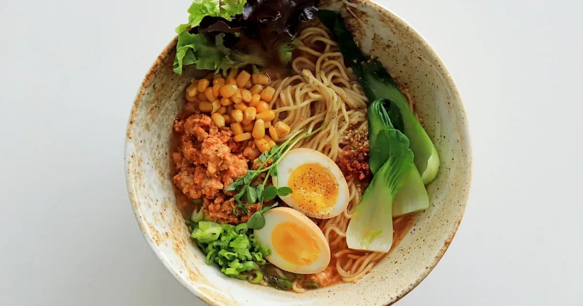 A bowl of vegan Japanese ramen with vegetables and a clear plant-based broth