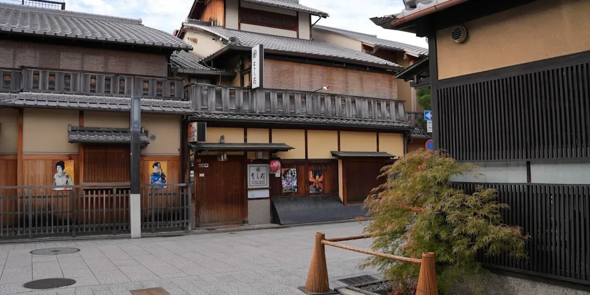 Traditional wooden machiya townhouses lining a stone-paved street in Kyoto's Gion district at dusk