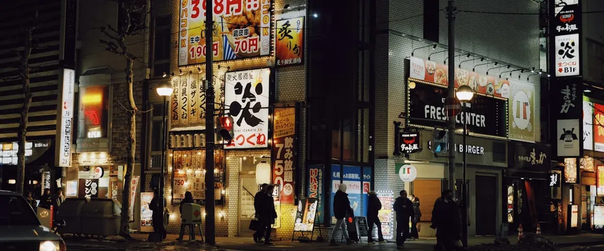 Susukino entertainment district in Sapporo at night with neon signs reflecting off the street