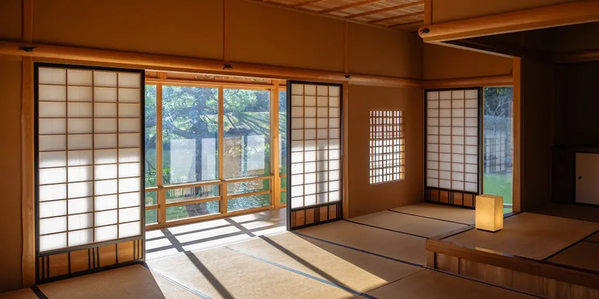 A traditional Japanese ryokan room with tatami mats, futon, and paper lanterns