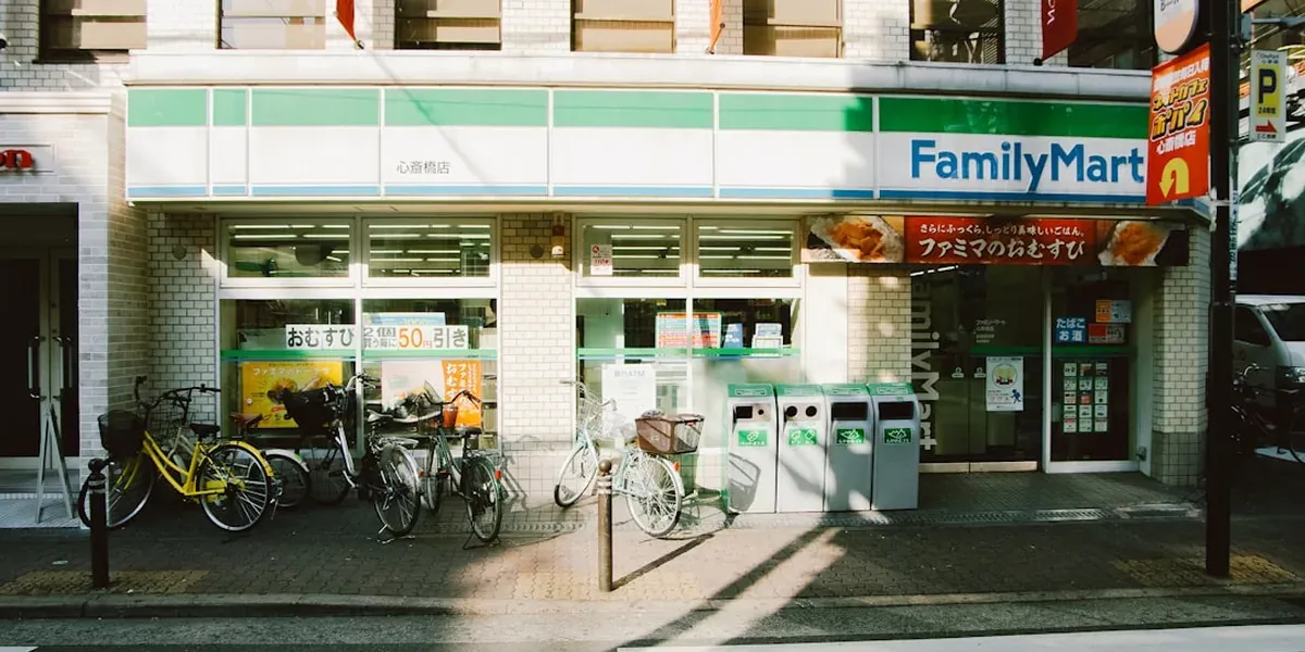 A Japanese convenience store shelf with onigiri, sandwiches, and snack items