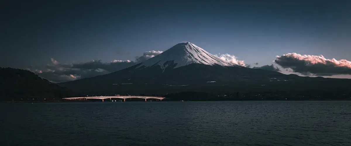 Mount Fuji at sunset with a pink and orange sky behind the snow-capped peak