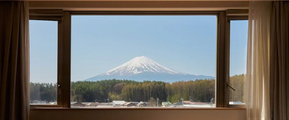 View from a Shinkansen window showing Japan countryside and distant Mount Fuji